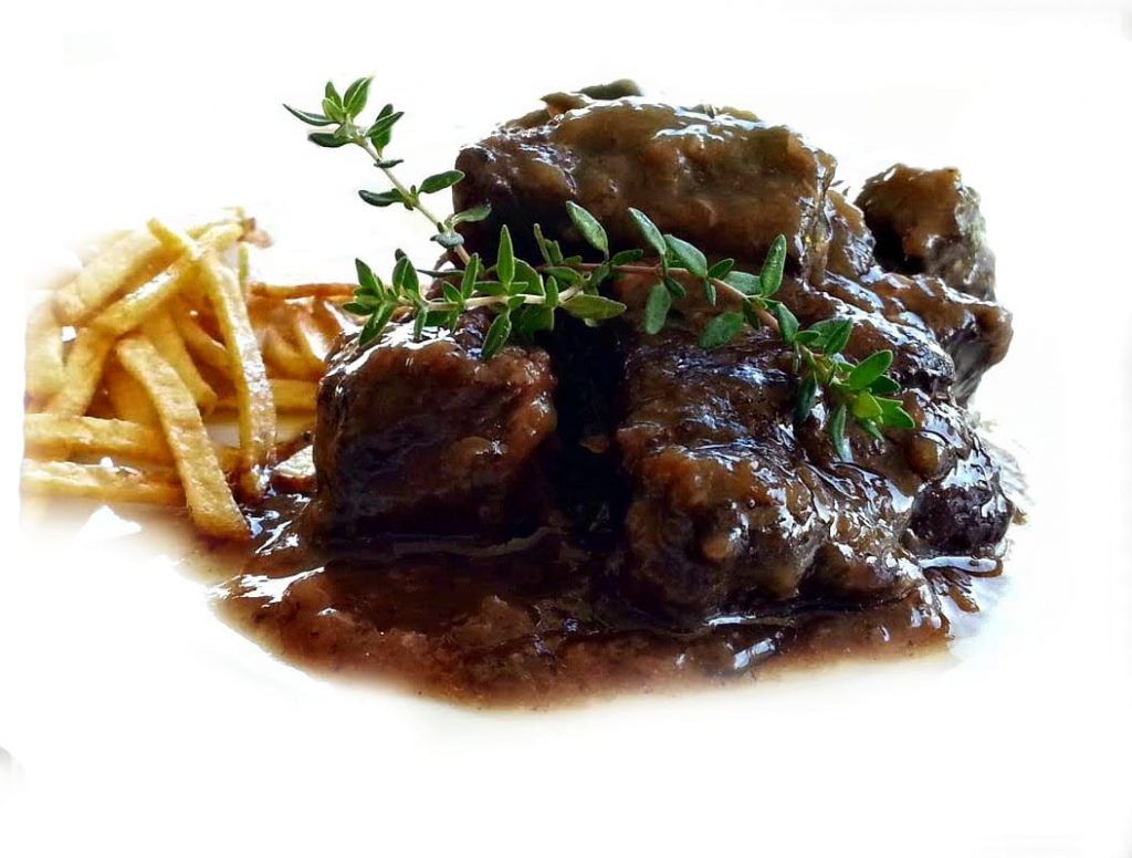 Ox cheeks braised in red wine sauce, topped with a sprig of thyme and served with straw potatoes